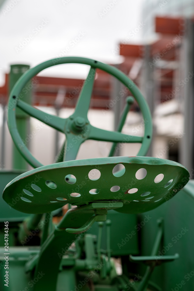 Close up of the seat of a tractor that has been painted green