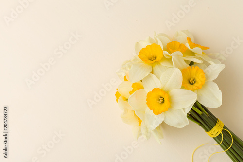Fototapeta Naklejka Na Ścianę i Meble -  White daffodil bouquet on yellow pastel background with copy space.