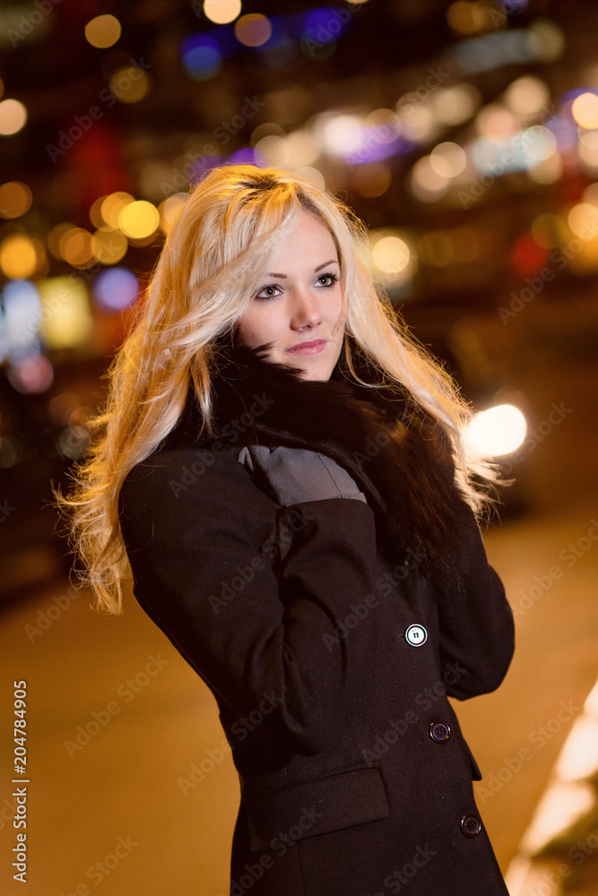 Fototapeta premium Beautiful, blonde woman in car lights in the night city.