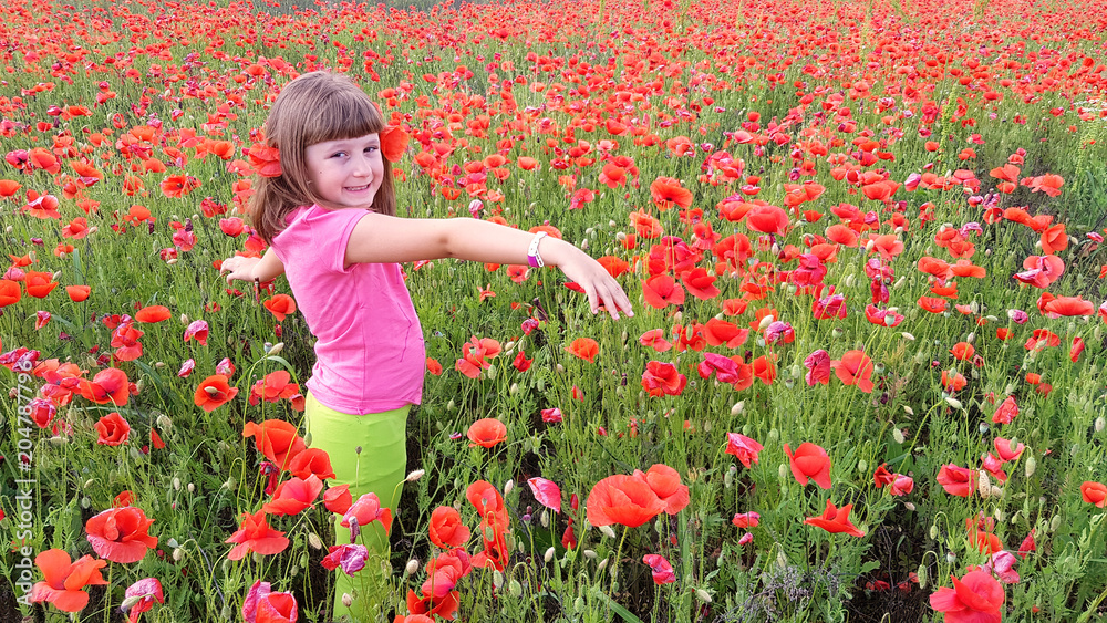 young girl walking into field of poppies