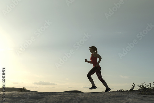 Woman silhouette running in sunset image