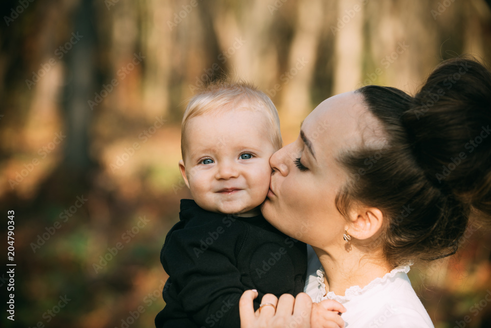 Mothers day concept. Mother kiss little son with love. Woman hug child. Mom and baby boy outdoor. Happy family enjoy sunny day. Love care and trust Mothers day concept. Mother kiss little son with love. Woman hug child. Mom and baby boy outdoor. Happy family enjoy sunny day. Love care and trust
