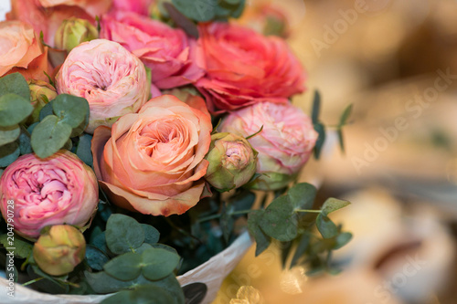 wedding  nature  arrangement concept. there is a marvelous bouquet of delicate flowers  carefully collected by florist  lovely roses of pink and orange colores and peonies
