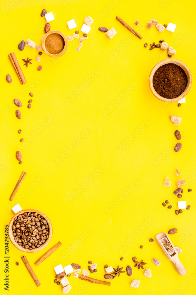 Fototapeta premium Ingredients for bakery and desserts. Cinnamon, cocoa, coffee, sugar, spices on yellow background top view space for text
