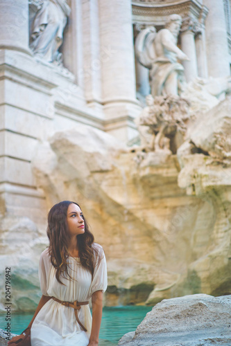 Woman in white dress in front of Trevi Fountain in Rome