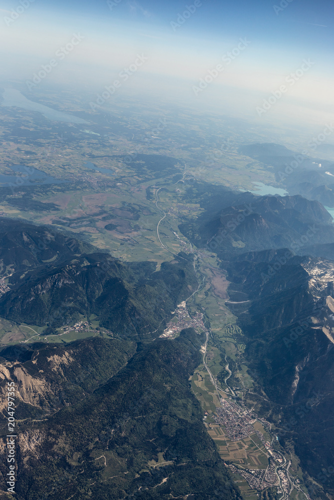 Obraz premium View from the airplane to the sky above the Alps mountains. Blue sky with clouds. Background.