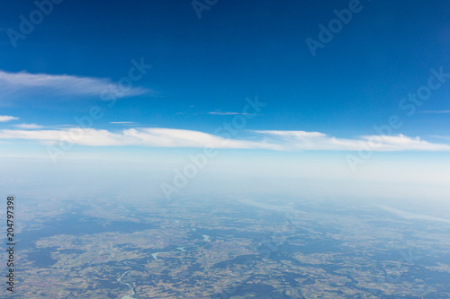 View from the airplane to the sky above the Alps mountains. Blue sky with clouds. Background. © A_Skorobogatova