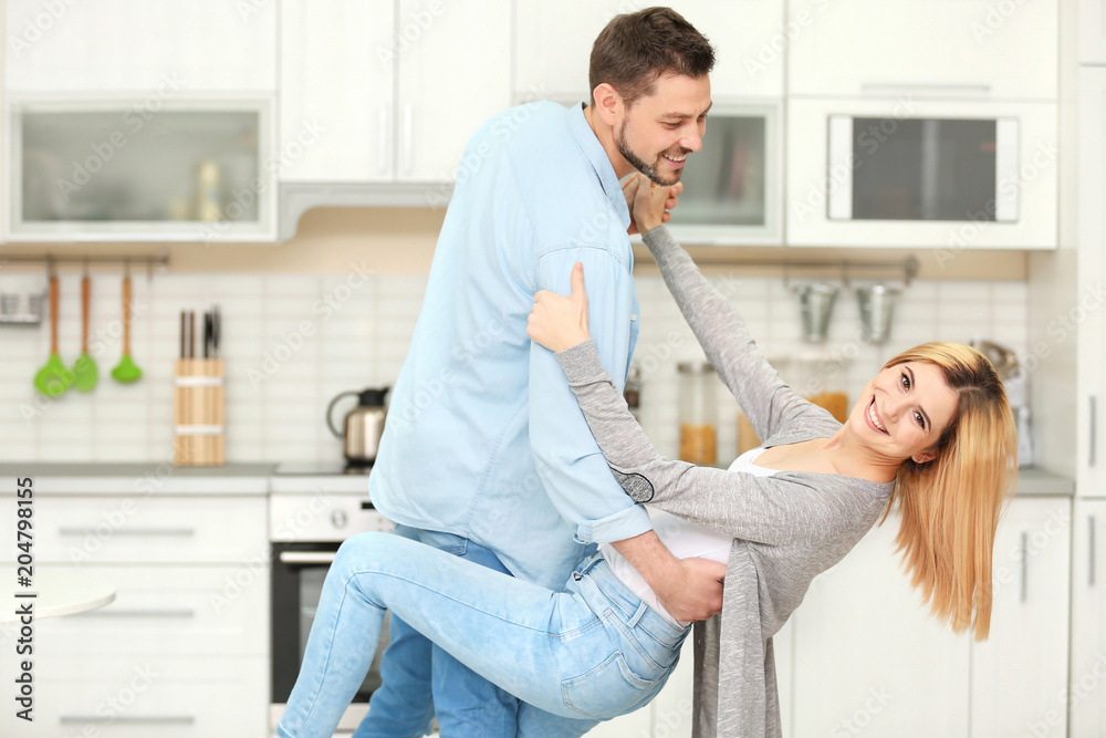 Obraz premium Happy couple dancing in kitchen
