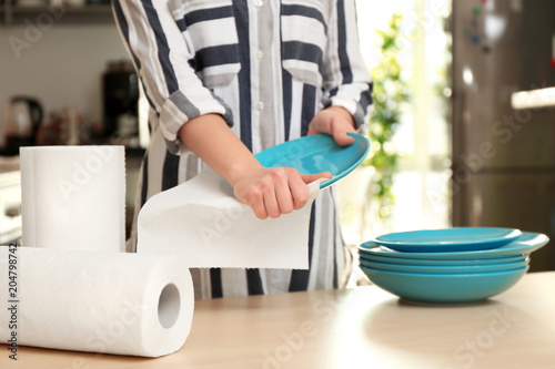 Woman wiping ceramic plate ...