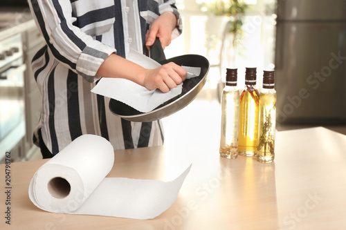 Woman wiping frying pan wit...