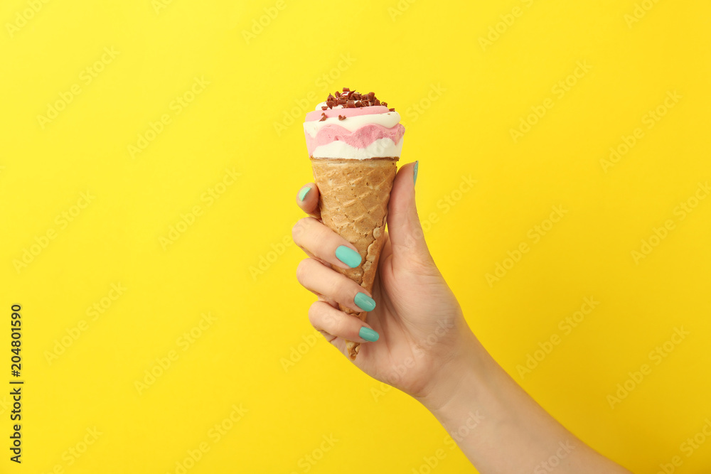 Woman holding yummy ice cream on color background. Focus on hand Woman holding yummy ice cream on color background. Focus on hand