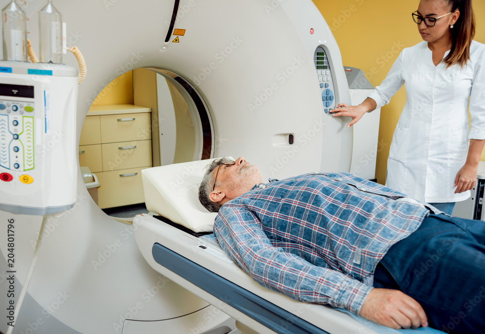 Doctor and patient in the room of computed tomography at hospital. Doctor and patient in the room of computed tomography at hospital.