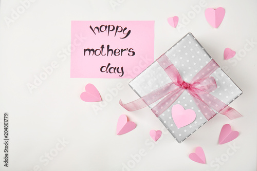 Flat lay composition with paper hearts and elegant gift box for Mother's Day on light background