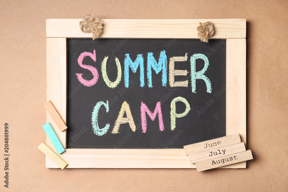 Obraz premium Composition with block calendar and words SUMMER CAMP written on small blackboard, top view