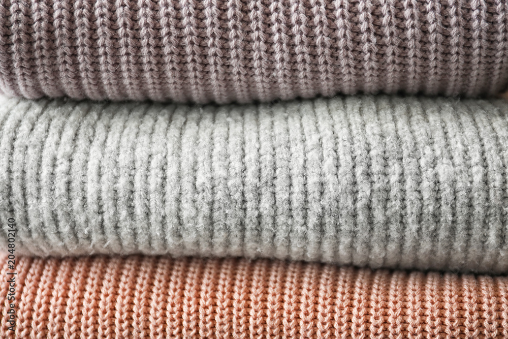 Stack of warm knitted clothes as background Stack of warm knitted clothes as background