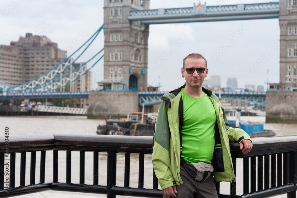 Caucasian man is standing on embankment of river Thames, on background Tower Bridge. Caucasian man is standing on embankment of river Thames, on background Tower Bridge.