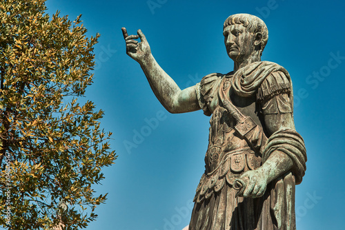 Rome, Bronze statue of emperor Caesar Nervae Trajan, Forum of Caesar Nervae Trajan in the background photo