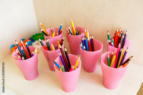 Color pencils in glass on desk with shallow depth of field Pencils in a glass on school desk