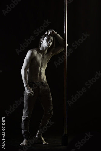 Tired dancer concept. Guy lean on metallic pole. © Volodymyr