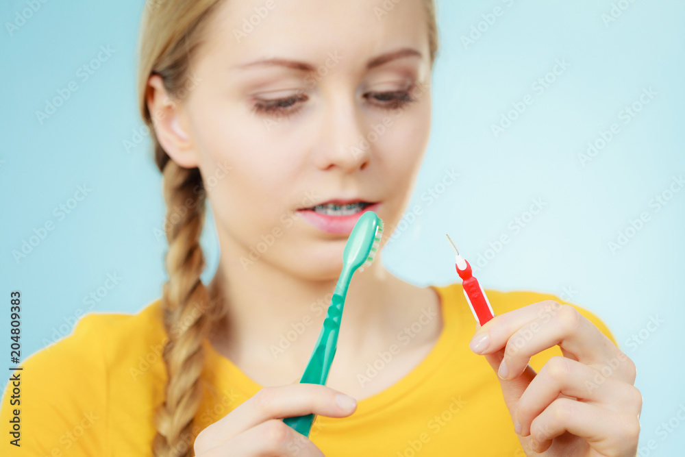 Girl with teeth braces using interdental and traditional brush