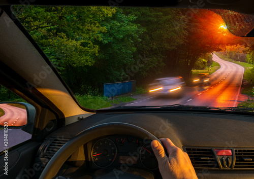 driver behind the wheel driving at sunset