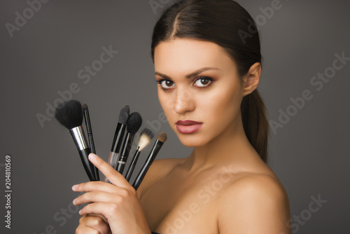beautiful girl with make up brushes , perfect skin and make up woman concept
