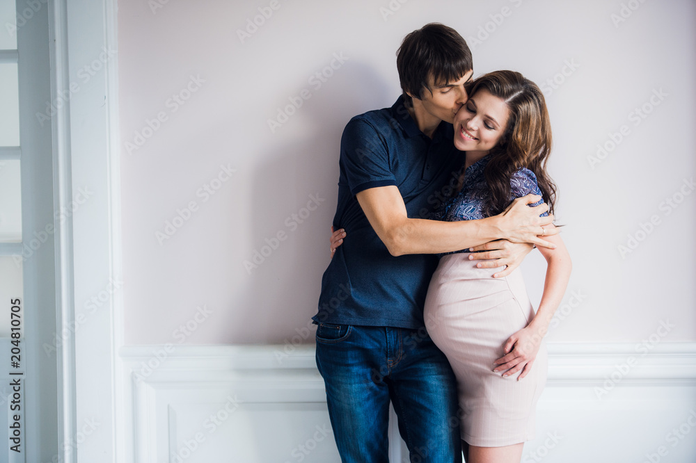 Smiling happy couple waiting for a child leans to each other at home Smiling happy couple waiting for a child leans to each other at home
