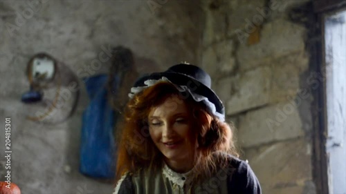 Red-haired girl with a big pumpkin in the hut. Fairy-tale character. Magic of miracles