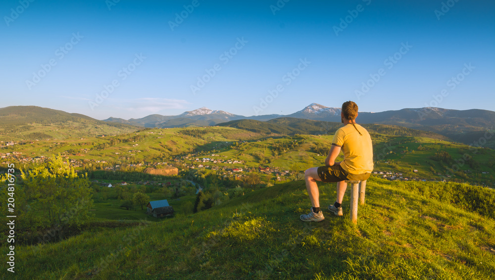Man hiker sitting on a wooden bench