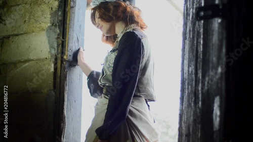 girl in an ethnic dress enters a country barn. Fairy-tale character. Cinderella photo