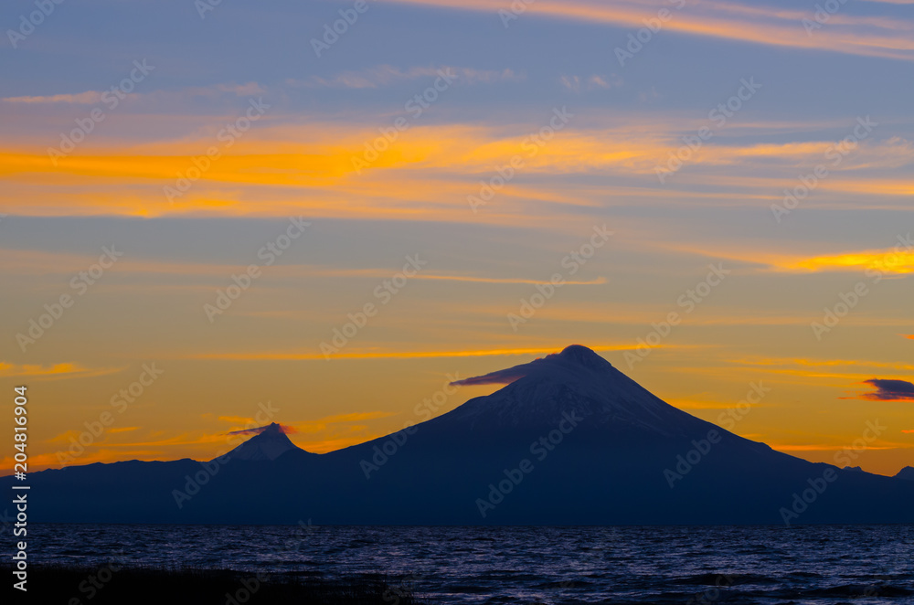 Sunrise in Lake Llanquihue and in the city of the same name, with the Osorno and Puntiagudo volcanoes at the background, southern Chile