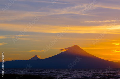 Sunrise in Lake Llanquihue and in the city of the same name  with the Osorno and Puntiagudo volcanoes at the background  southern Chile