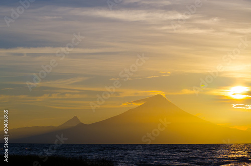 Sunrise in Lake Llanquihue and in the city of the same name  with the Osorno and Puntiagudo volcanoes at the background  southern Chile