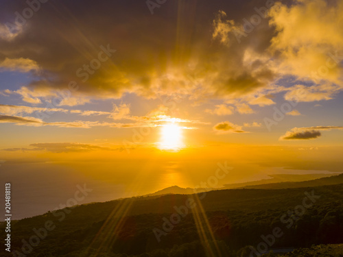 Aerial view of the landscape of Lake Llanquihue at sunset, you can see the sun shining on the horizon surrounded by clouds, southern Chile © MAV Drone