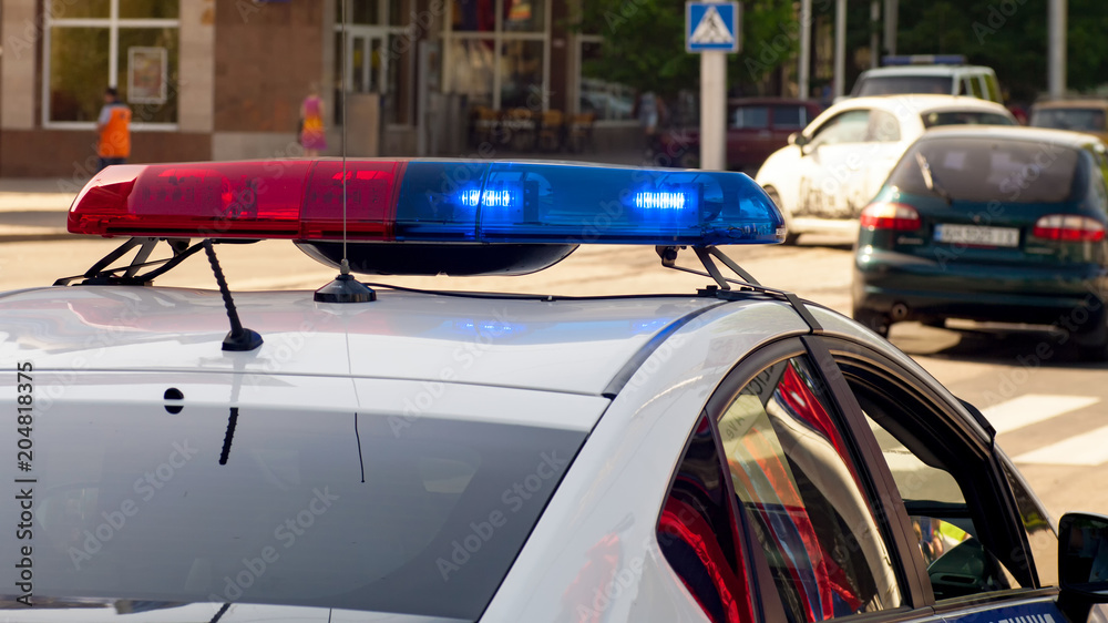Police patrol car with flashing lights on the city road. Police patrol car with flashing lights on the city road.