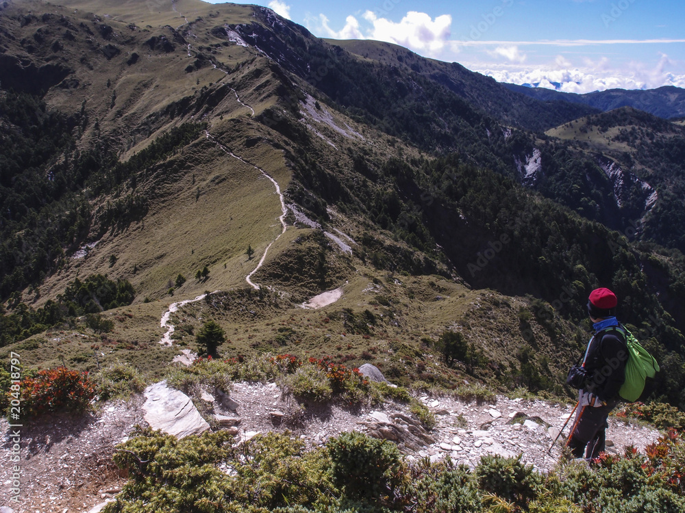 A male hiker standing on a platform and enjoying the beautiful alpine landscape of Taiwan.