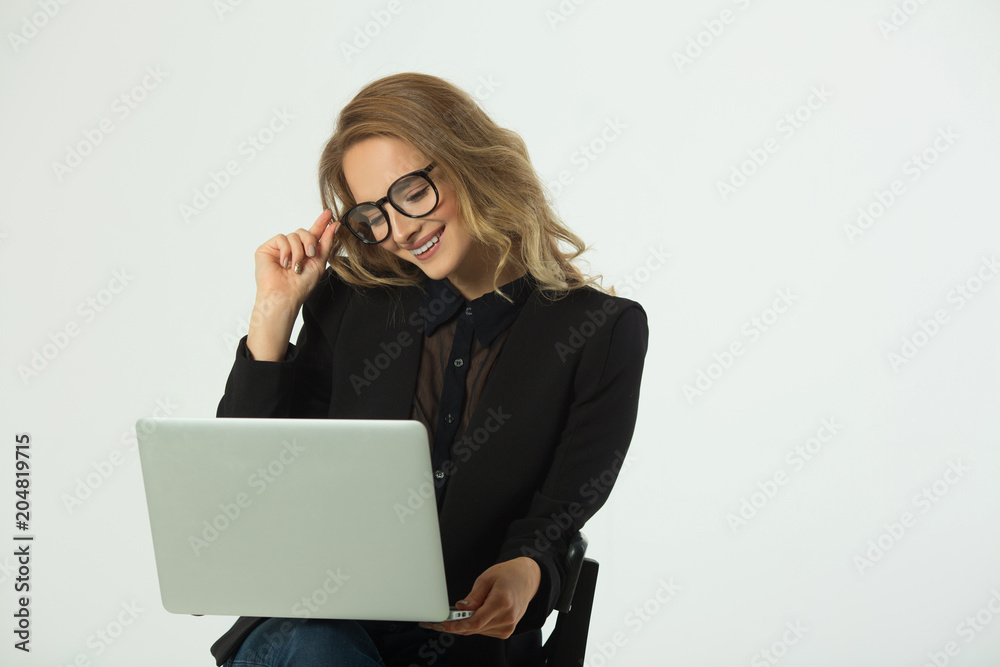 beautiful young girl with glasses in a black suit with a laptop on a white background beautiful young girl with glasses in a black suit with a laptop on a white background