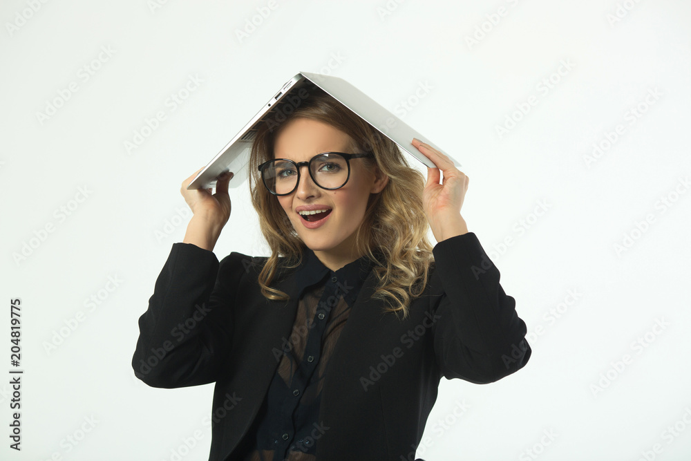 beautiful young girl with glasses in a black suit with a laptop on her head against a white background beautiful young girl with glasses in a black suit with a laptop on her head against a white background