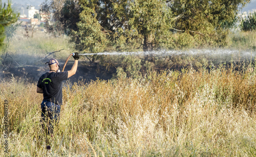 Firefighter fire extinguishing  field with dry grass © John Vlahidis