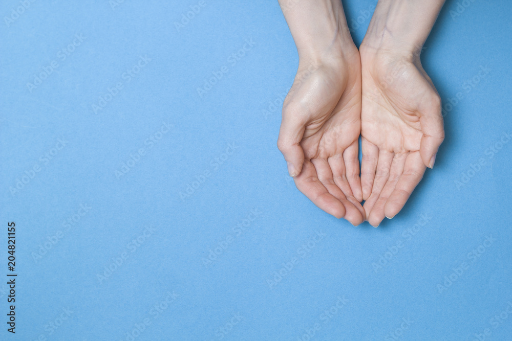 Fototapeta premium Empty palms up isolated on a blue background. Copy space.