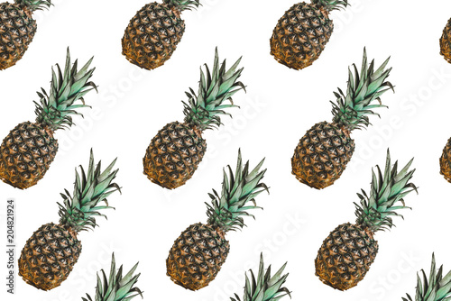 Pattern with pineapples on white background. Colorful fruit pattern of fresh pineapples on white background. Top view on pineapples.