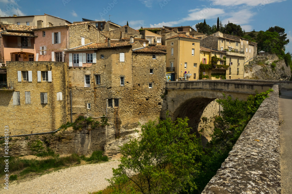 Old medieval part of the French Vaison-la-Romaine city with old roman bridge in a foreground.