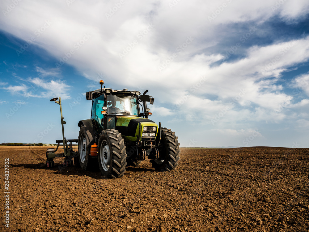 Farmer seeding, sowing crops at field. Sowing is the process of planting seeds in the ground as part of the early spring time agricultural activities. Farmer seeding, sowing crops at field. Sowing is the process of planting seeds in the ground as part of the early spring time agricultural activities.