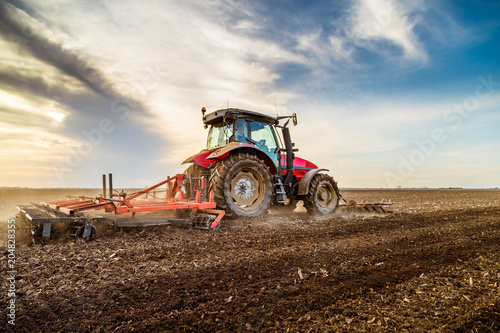 Tractor cultivating field a...