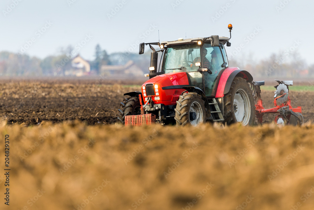 Obraz premium Farmer plowing stubble field