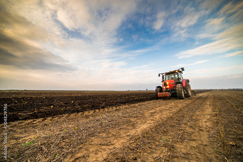 Farmer plowing stubble field Farmer plowing stubble field
