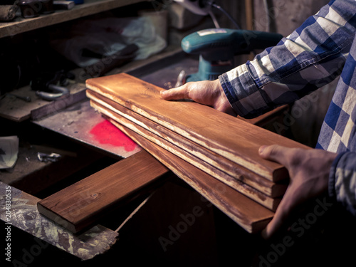 wooden plank in the hand of man working in the dark room