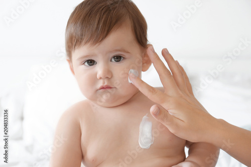 Woman applying body cream o...