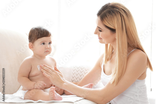 Woman applying body cream o...