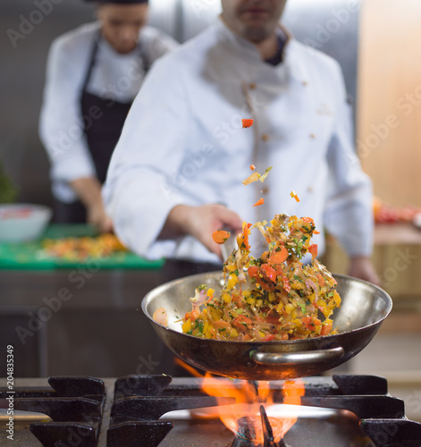Tablou pe pânză chef flipping vegetables in wok